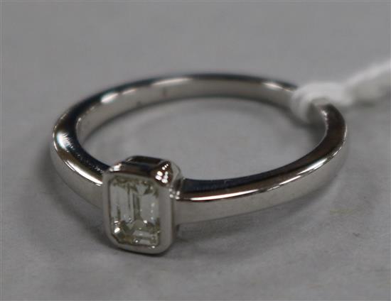 A modern 18ct white gold and solitaire baguette cut diamond ring, size M.